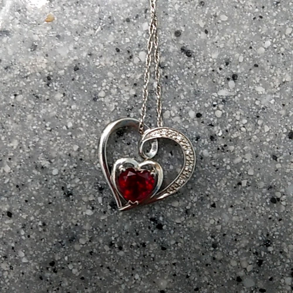 Silver necklace with red gem in the middle